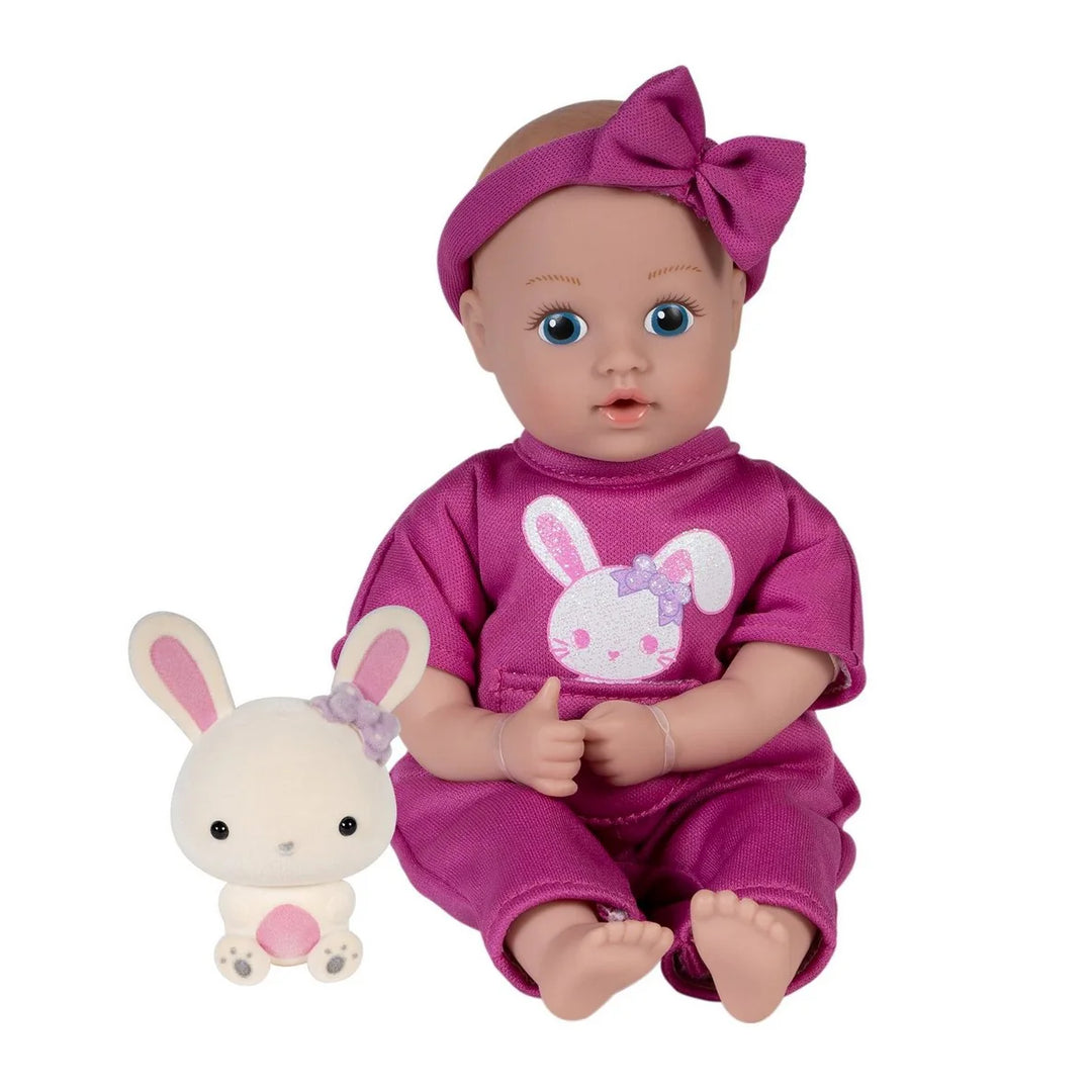 adora Baby doll in pink outfit with bunny design and matching plush toy on a white background