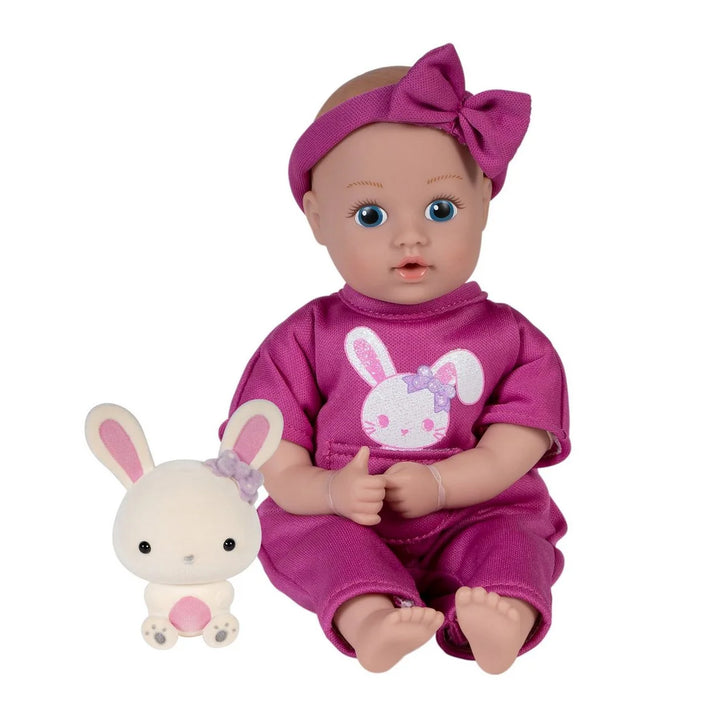 adora Baby doll in pink outfit with bunny design and matching plush toy on a white background