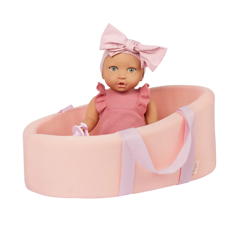 LullaBaby Doll and Carrier Bassinet Baby doll in a pink bassinet with a matching bow headband on a white background