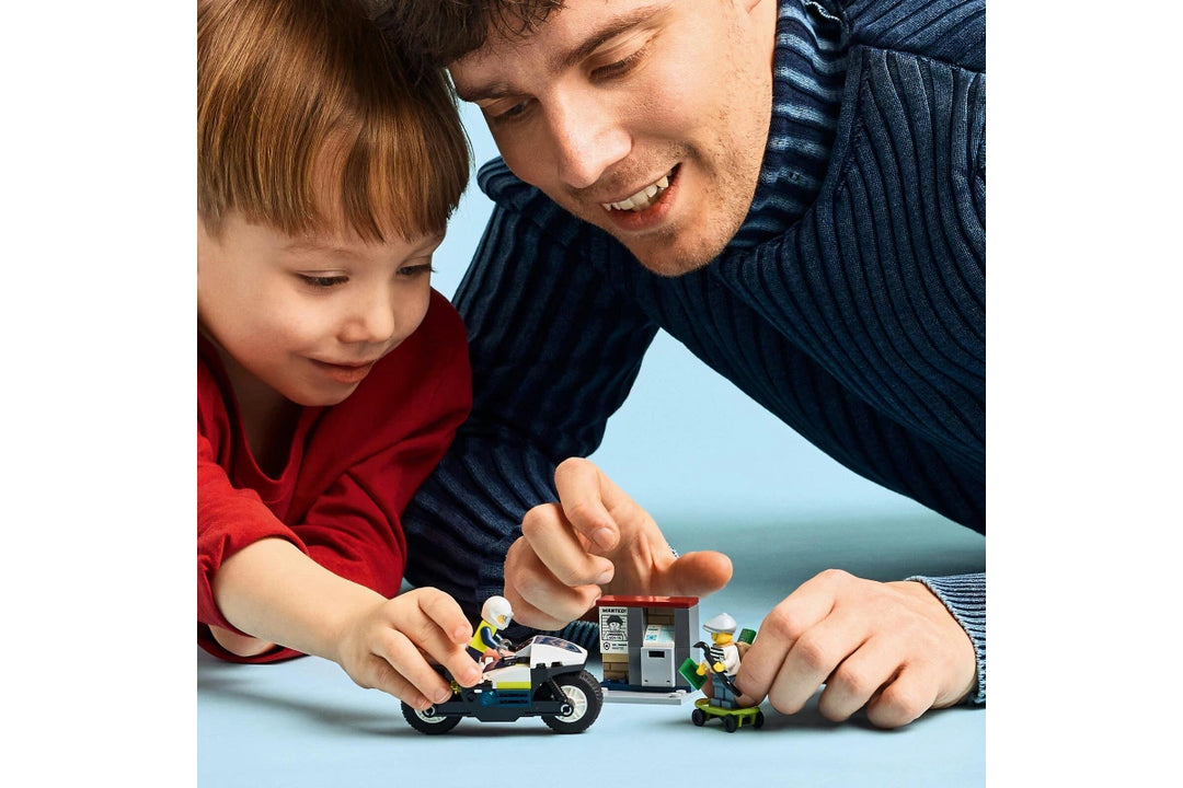 Man and child playing with toy cars on a light blue background
