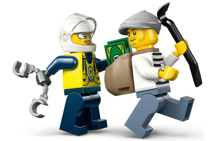 Two LEGO figures, one with a tool and the other with a bag and crowbar, on a white background