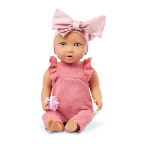 Baby doll in pink outfit with a large bow on a white background