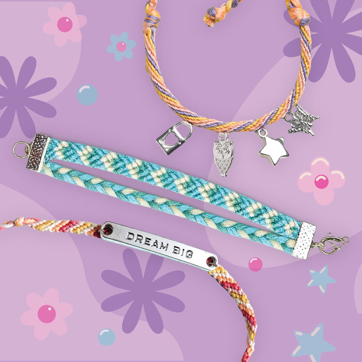 Three colorful braided and woven bracelets arranged on a lavender floral background. One bracelet has pastel blue, white, and yellow plaid with silver charms including a padlock, heart, star, and butterfly.