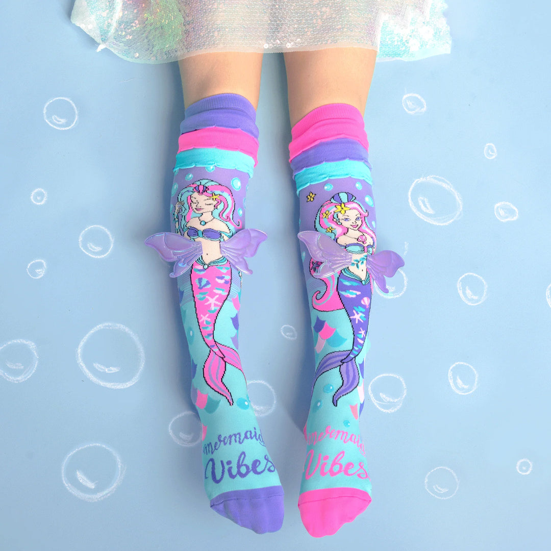 Colorful mermaid-themed socks with 'Mermaid Vibes' text on a light blue background.