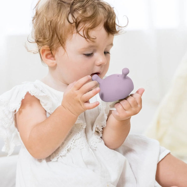 Child holding a Mombella Mushroom Soothing Teether Lavender Fog