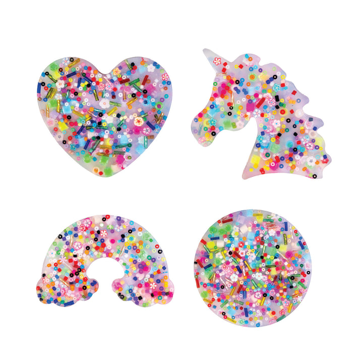 Colorful glittery heart, unicorn, and number 6 shapes on a white background