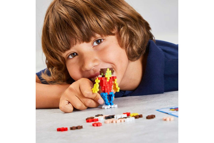 Child playing with colorful Plus plus basic 100 pieces building blocks on a table