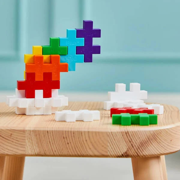 Colorful toy blocks on a wooden table with a light blue background