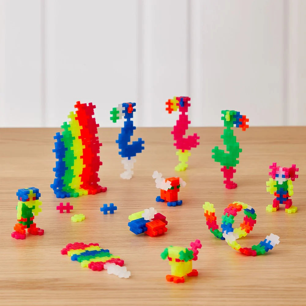 Colorful building block toys on a wooden surface with a white curtain background