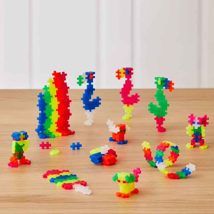 Colorful building block toys on a wooden surface with a white curtain background