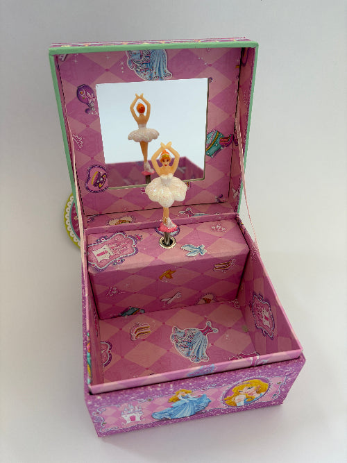 A pink fairy tale music box with ballerina figurines, featuring a mirror on the inside lid and princess illustrations on the exterior.
