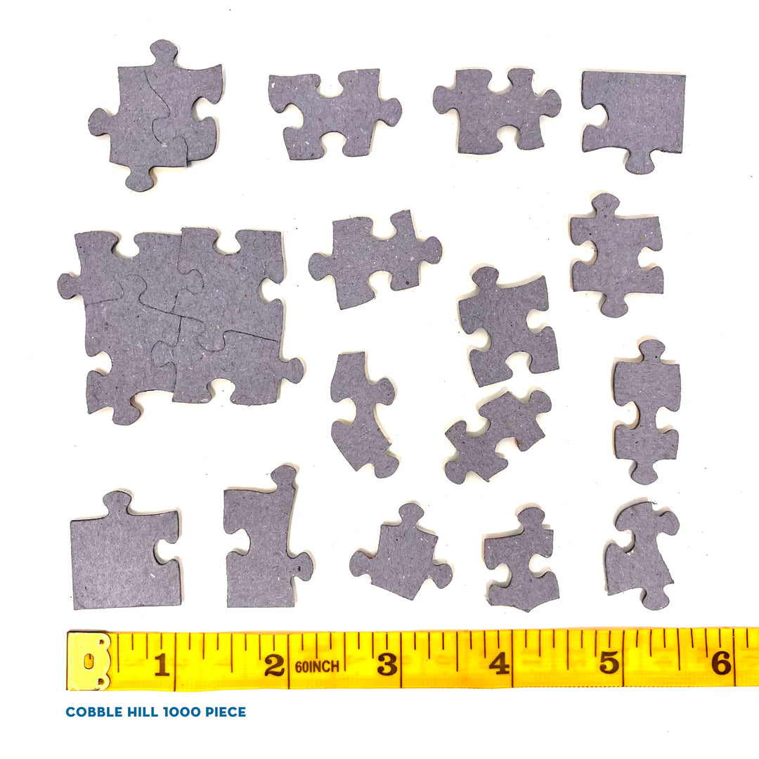 Jigsaw puzzle pieces with a measuring tape for scale on a white background