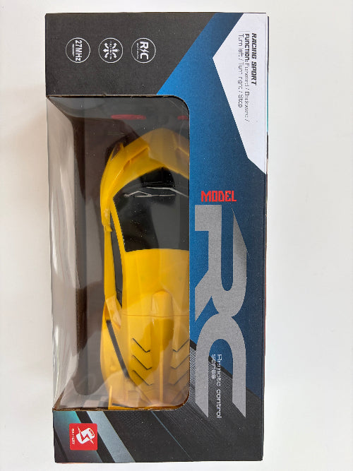 Yellow remote control car in packaging with 'RC' branding on a white background