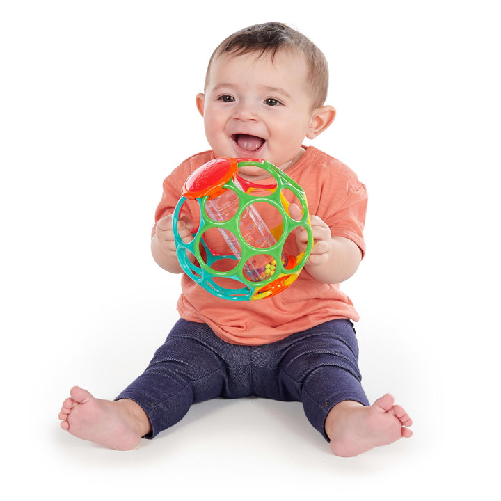 baby playing with rollin rainstick over a white background