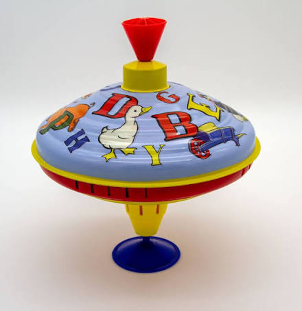 spinning ABC humming top out of packing on counter, duck and letters on design