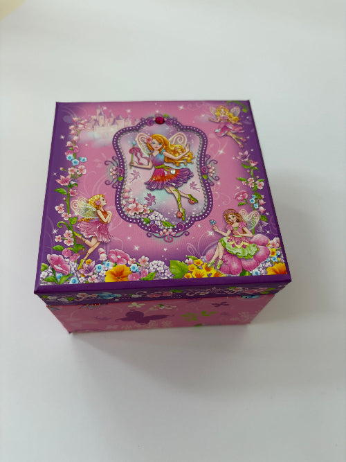 A square purple decorative box with a colorful fairy illustration on the lid, photographed on a plain white surface.