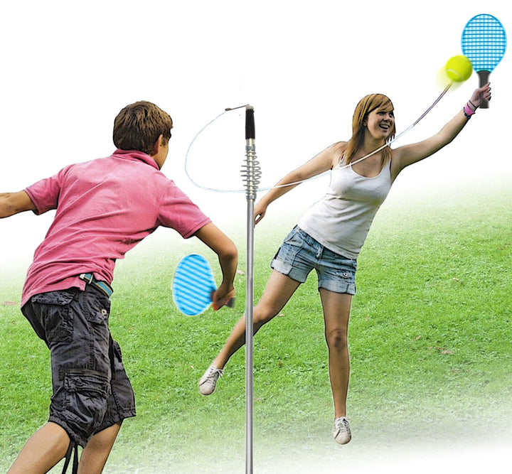 Two people playing with badminton rackets and shuttlecocks on a grassy background