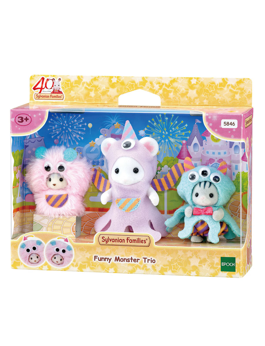 Packaged set of three colorful monster figurines with a castle background on the packaging.