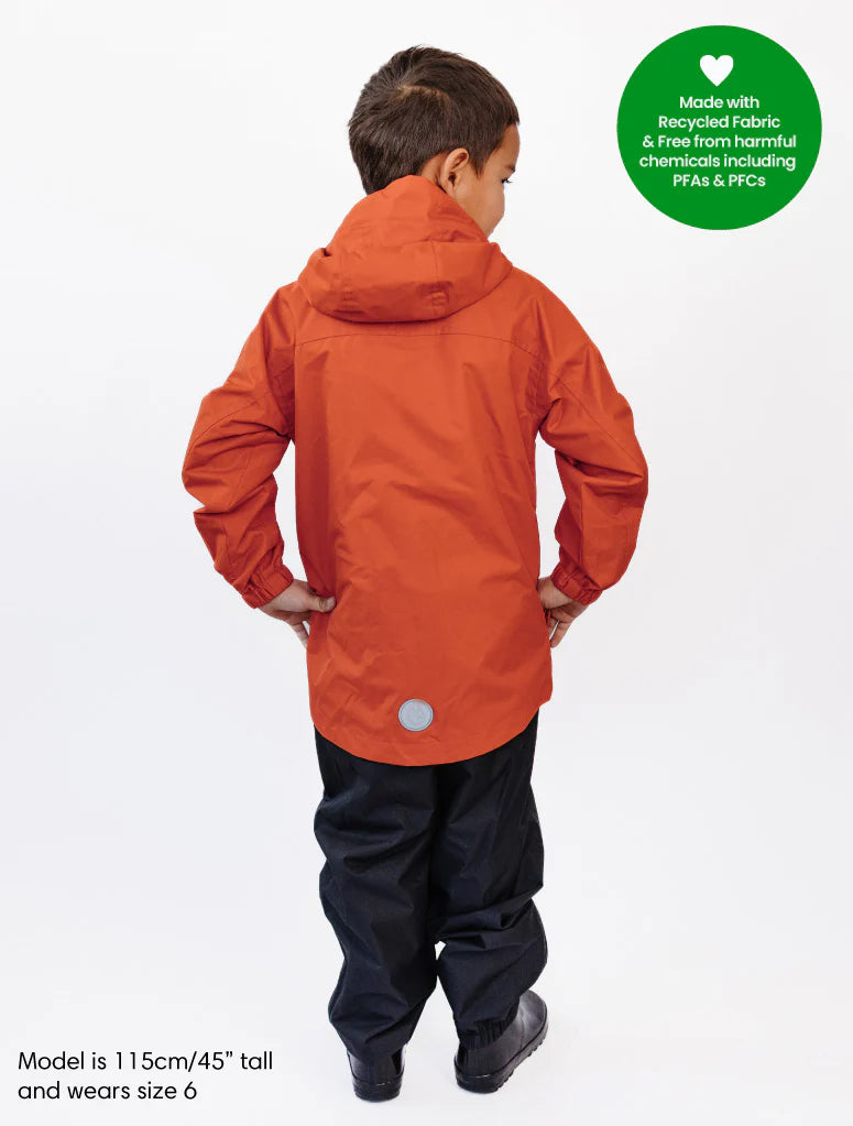 Child wearing an therm raincoat with a green label indicating recycled fabric and chemical-free properties on a white background.