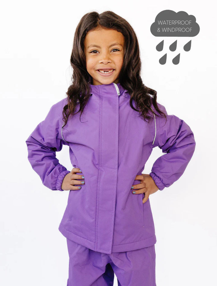 Child wearing a purple waterproof outfit with a white background