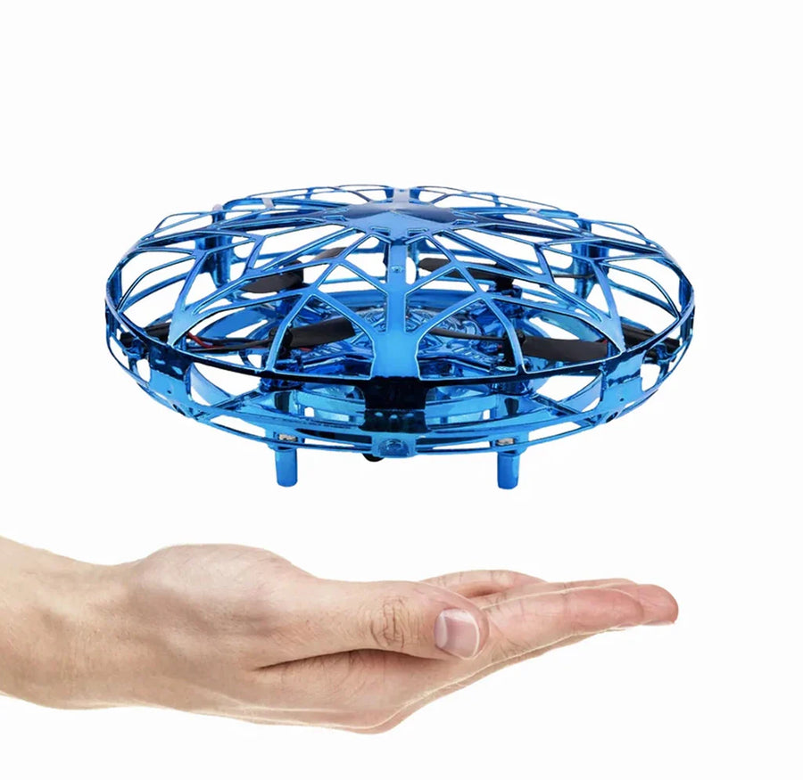 Blue drone hovering above a person's hand on a white background