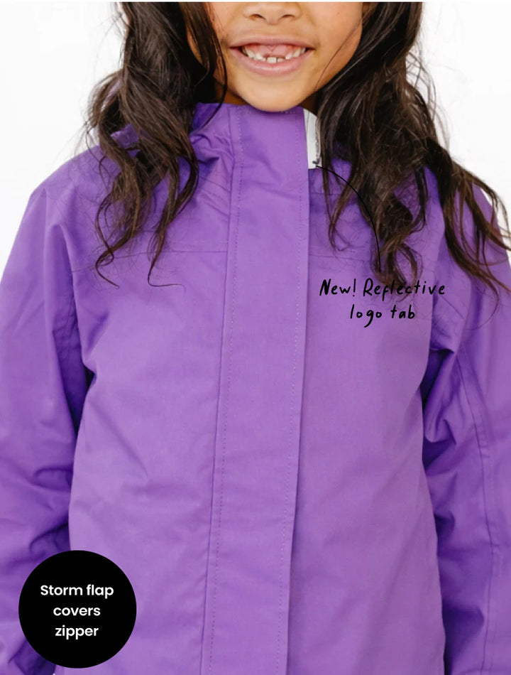 Purple jacket with reflective logo tab feature on a white background