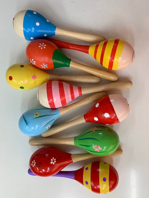 A collection of colorful wooden maracas in various colors including blue, red, green, and yellow, laid out on a white surface. kidzstuffonline
